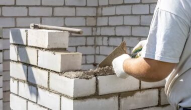 Homem com camisa branca construindo um muro de arrimo